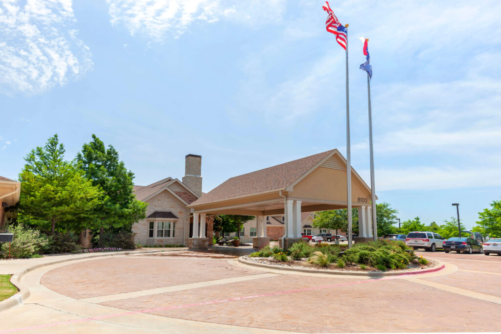 Covered Entrance and Flagpoles at Front of Memory Care Community